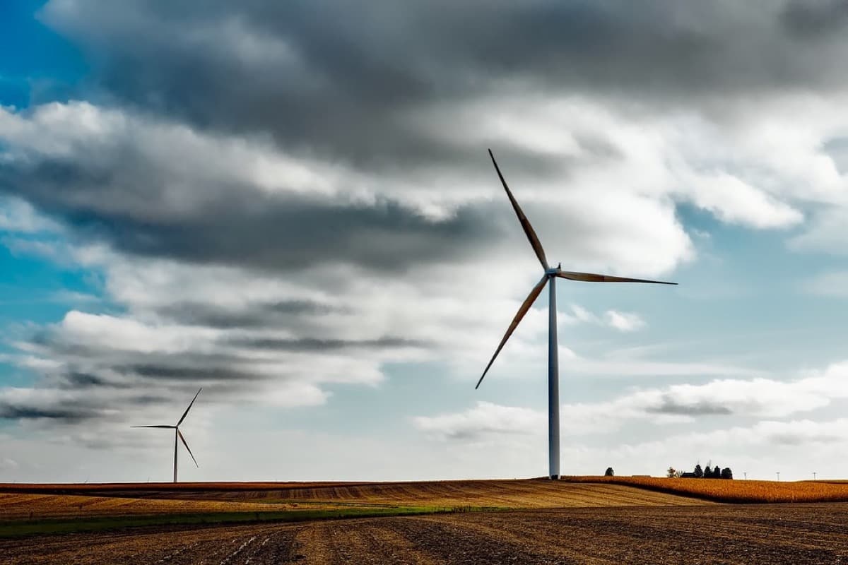 A wind turbine rotor against heavy cloud, the weather that wears a blade's leading edge over years